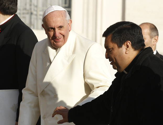 Pope Francis walks with Fr. Fabian Baez from Buenos Aires, Argentina, as the pope arrived to lead his general audience Wednesday in St. Peter's Square at the Vatican. The pope spotted the priest in the crowd and invited him to board the popemobile. (CNS/Paul Haring)