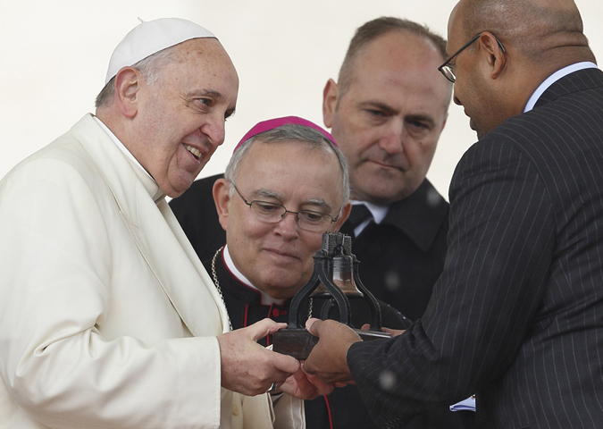Pope Francis accepts a replica of the Liberty Bell from Philadelphia Mayor Michael Nutter as Philadelphia Archbishop Charles Chaput looks on during the pope's general audience March 26 in St. Peter's Square at the Vatican. (CNS/Paul Haring)