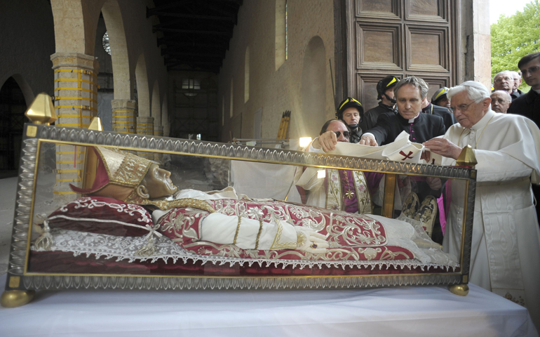 Pope Benedict XVI places his pallium on the remains of 13th-century Pope St. Celestine V during Benedict's 2009 visit to the earthquake-damaged Basilica of Santa Maria di Collemaggio in L'Aquila, Italy. (CNS/Reuters/L'Osservatore Romano)