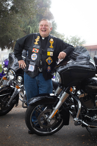 Miami Archbishop Thomas Wenski leans on his Harley Davidson motorcycle Feb. 9 at Mary Help of Christians Church near Fort Lauderdale, Fla., before the opening Mass for the second annual Archbishop's Poker Run charity ride. (CNS/Tom Tracy) 
