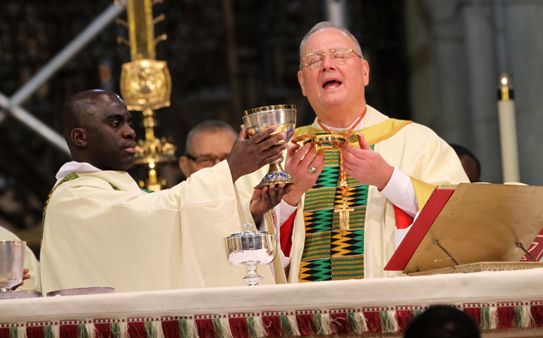 Cardinal Timothy Dolan of New York, right, and Deacon Jean Marie Uzabakiriho, who was born in Rwanda and is a fourth-year seminarian at St. Joseph's Seminary in Yonkers, N.Y., elevate the Eucharist Sunday during an annual Black History Month Mass at St. Patrick's Cathedral in New York. (CNS/Gregory A. Shemitz) 