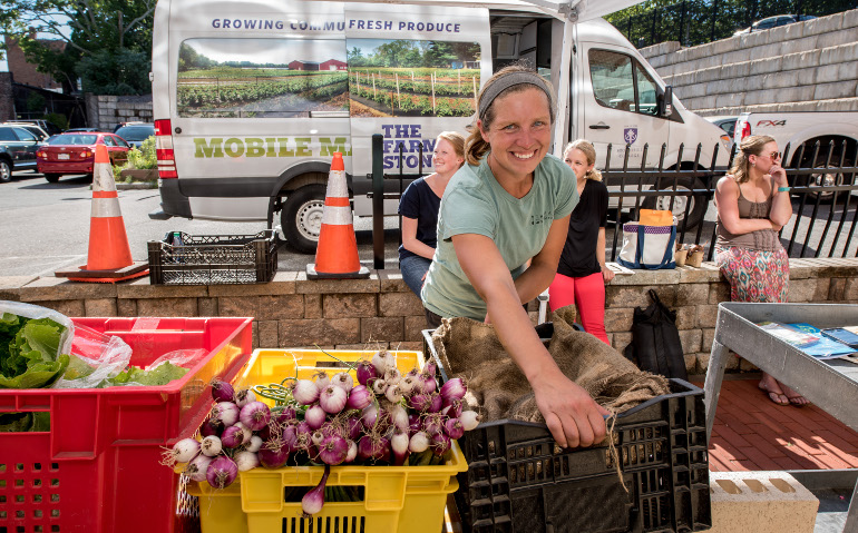 Bridget Meigs, manager of the Farm at Stonehill, sets up the Mobile Market stall in downtown Brockton, Mass. (Courtesy of Stonehill College)