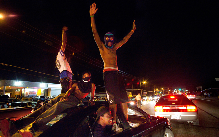 Protesters demonstrating against the shooting death of an unarmed teenager named Michael Brown ride through the streets in Ferguson, Mo., Aug. 14. (CNS/St. Louis Review/Lisa Johnston)