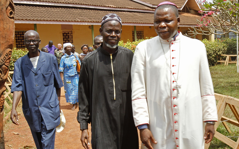 Archbishop Dieudonne Nzapalainga of Bangui, Central African Republic, right, walks with Imam Oumar Kobine Layama, center, in Bangui after a meeting of religious representatives, Bangui residents and African and French peacekeeping forces Feb. 10. (CNS/Reuters/Luc Gnago)