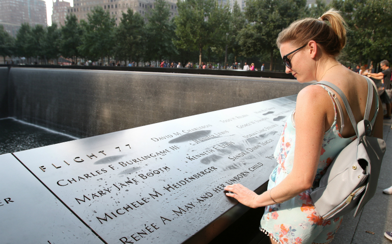 A woman reads the names of people killed in the Sept. 11, 2001, terrorist attacks at the South Pool of the 9/11 Memorial in New York City September 2015. (CNS photo/Gregory A. Shemitz)