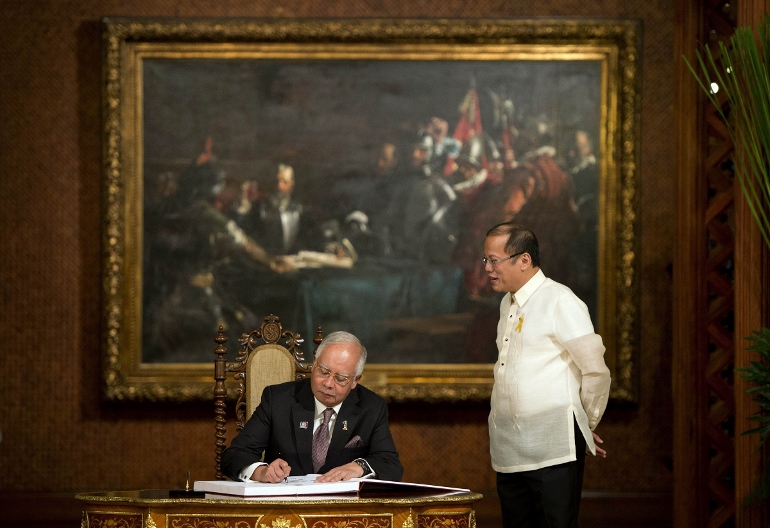 Philippine President Benigno Aquino stands beside Malaysia's Prime Minister Najib Razak as he signs the guest book at Malacanang Palace in Manila, before the signing of a peace pact with the Moro Islamic Liberation Front March 27. (CNS/Reuters/Noel Celis, pool)