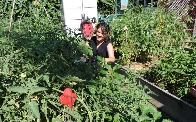Bethany Welsh, founding director of the Aquinas Center in a South Philadelphia neighborhood, stands in the middle of the center's garden July 27. (CNS/Elizabeth Eisenstadt Evans)