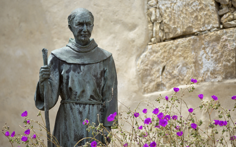 A statue of St. Junipero Serra sits among flowers outside San Carlos Borromeo de Carmelo Mission in Carmel, Calif. The Spanish missionary was canonized by Pope Francis last year under the title of "apostle of California." St. Junipero's feast is July 1. (CNS photo/Nancy Wiechec)