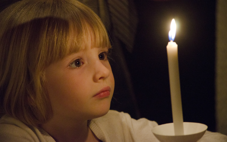 A girl contemplates her Easter candle during the Easter Vigil April 15 in the Cathedral of the Immaculate Conception in Wichita, Kansas. (CNS photo/Christopher Riggs, The Catholic Advance)