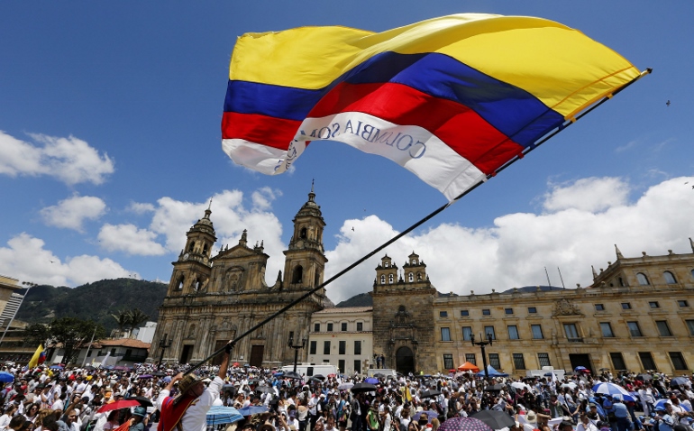 A man waves a national flag during the "March For Life" March 8 in Bogota, Colombia. The event supported peace negotiations between the government and the Revolutionary Armed Forces of Colombia. (CNS photo/John Vizcaino, Reuters)