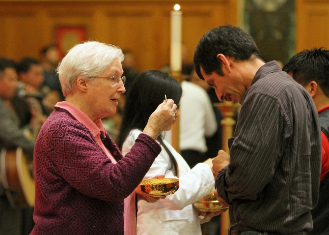 Sr. Margaret Smyth, director of the Riverhead, N.Y.-based North Fork Spanish Apostolate, distributes Communion during a Spanish-language Mass in January at St. John the Evangelist Church in Riverhead. Smyth, 75, a member of the Sisters of St. Dominic of Amityville, N.Y., has ministered to Latino immigrants on Long Island's East End since 1997. (CNS photo/Gregory A. Shemitz)