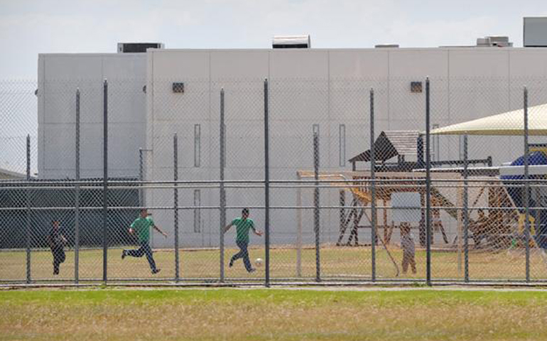 Children play in a double-fenced playground area in 2009 outside the T. Don Hutto Family Residential Facility in Taylor, Texas. (CNS/Bahram Mark Sobhani)