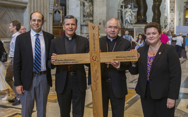 Leaders in ministry to U.S. Hispanic Catholics stand in St. Peter's Basilica at the Vatican in 2016 with the Encuentro cross: Alejandro Aguilera-Titus, national coordinator of V Encuentro; Archbishop Gustavo Garcia-Siller, Archbishop Jose H. Gomez and Mar Munoz-Visoso, executive director of the U.S. bishops' Secretariat of Cultural Diversity in the Church. (CNS/Robert Duncan)