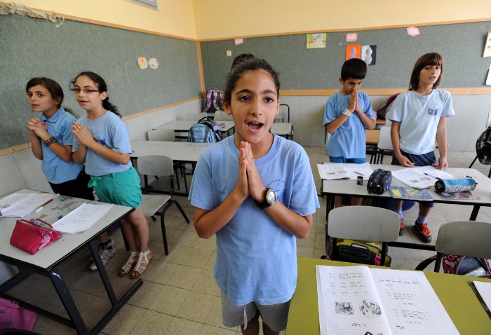 Israeli-Arab fourth-grade students pray in Aramaic during language class in 2012 at Jish Elementary School in Israel. Dozens of Christian schools in Israel may be shutting their doors this coming school year due to increasing restrictions by the Israeli government, Christian educators warn. (CNS photo/Debbie Hill)