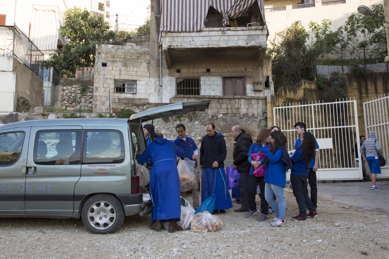 Students at St. George School in the Zalka section of Beirut help Mission of Life brothers fill a van with aid distributed during a Lenten outreach March 14. (CNS photo/Dalia Khamissy)