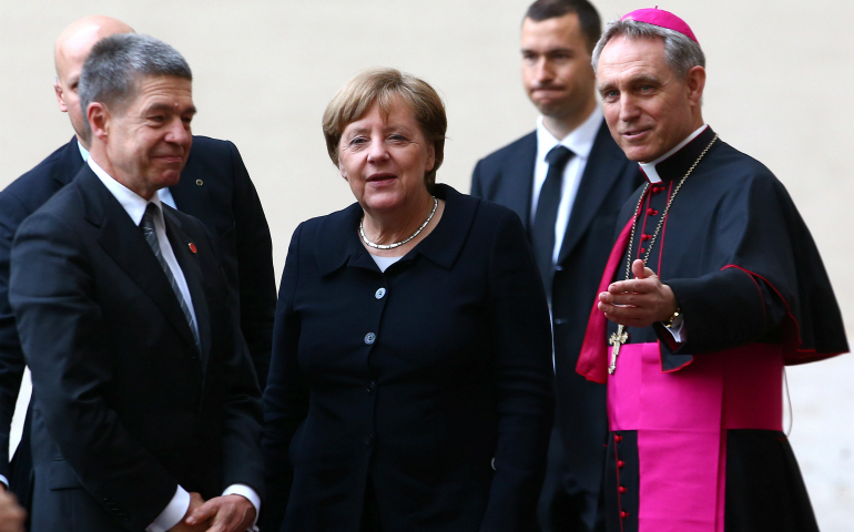 Archbishop Georg Ganswein, prefect of the papal household, right, greets German Chancellor Angela Merkel and her husband, Joachim Sauer, as they arrive March 24 for the European Union summit with Pope Francis at the Vatican. (CNS photo/Alessandro Bianchi, Reuters)