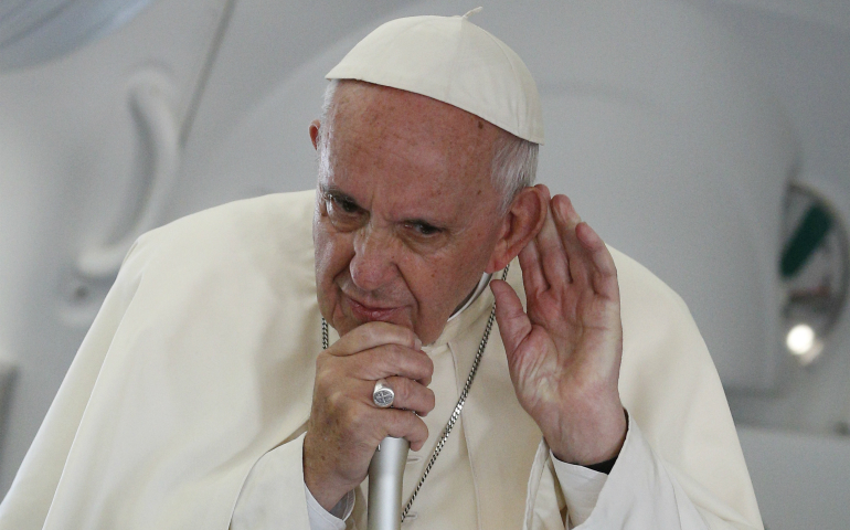 Pope Francis listens to a question from a journalist aboard his July 31 flight from Krakow, Poland, to Rome. (CNS photo/Paul Haring)