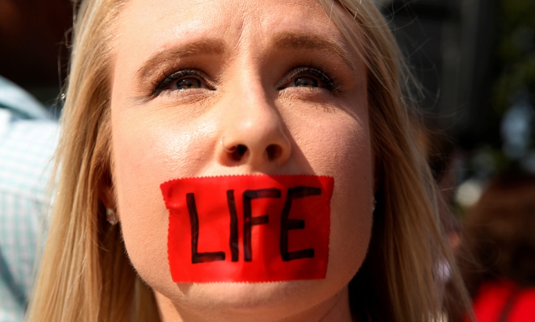 A pro-life supporter stands outside the U.S. Supreme Court June 27 during protests in Washington. In a 5-3 vote that day, the U.S. Supreme Court struck down restrictions on Texas abortion clinics that required them to comply with standards of ambulatory surgical centers and required their doctors to have admitting privileges at local hospitals. (CNS photo/Kevin Lamarque, EPA)