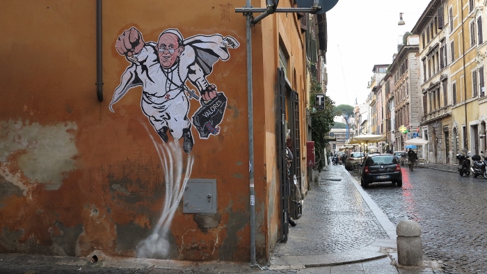 A large drawing of Pope Francis depicting him as a superhero is seen on a wall near the Vatican Jan. 29, 2014. The Argentine pope is shown taking off into the air with his right fist clenched in a classic Superman style. (CNS/Robert Duncan)