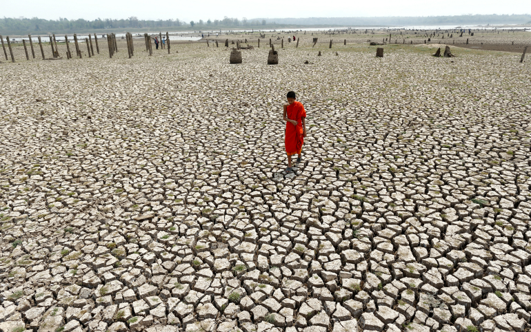 A Buddhist novice monk walks on parched land in Lampang, Thailand, March 2016. (CNS photo/Rungroj Yongrit, EPA) 