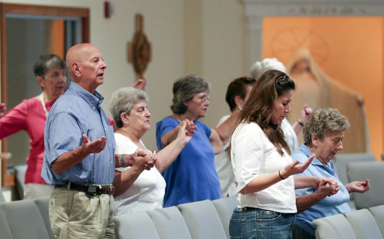 Parishioners join hands as they pray the Our Father during an Aug. 27, 2015, Mass at Resurrection Catholic Church in Moneta, Virginia. (CNS photo/Chris Keane, Reuters)