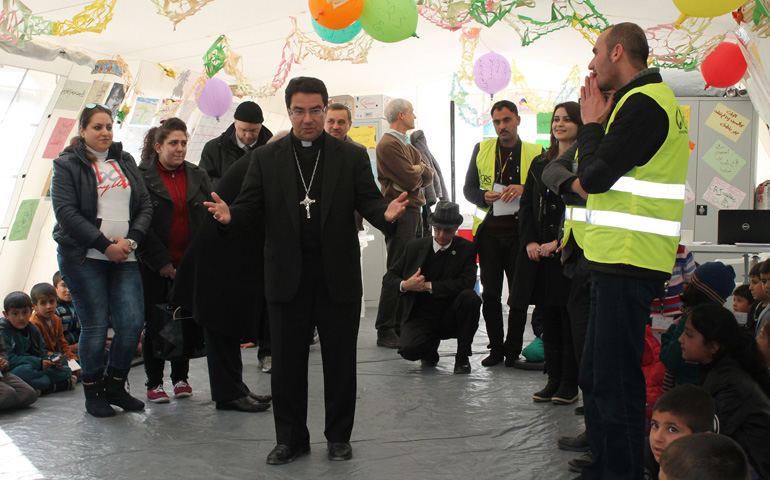 Bishop Oscar Cantu of Las Cruces, N.M., chats with displaced Yezidi children Jan. 20 outside of Dohuk during a recent visit to the Kurdistan region of Iraq. (CNS/Dale Gavlak)