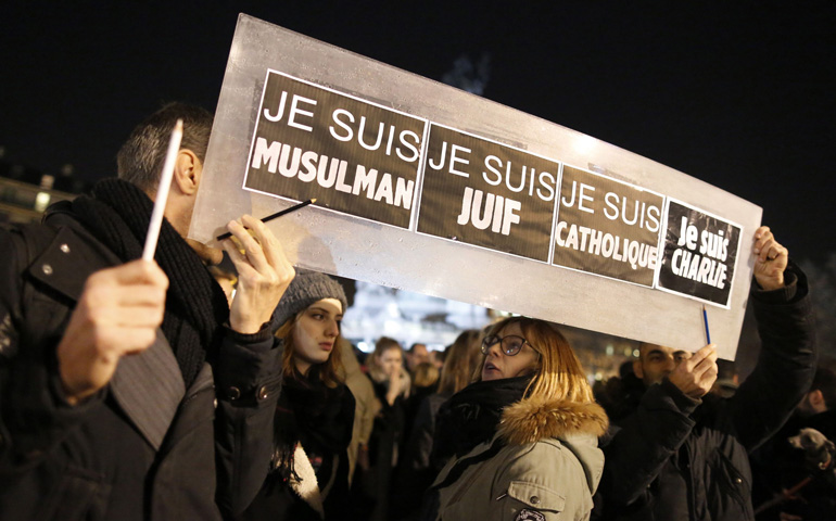 People hold a placard that reads, "I am Muslim, I am Jewish, I am Catholic, I am Charlie" at a Jan. 8 vigil in Paris. (CNS/Reuters/Jacky Naegelen)