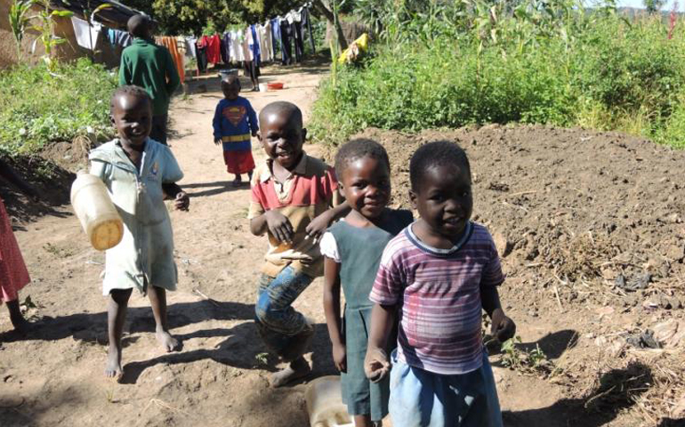 Children walk in their village of Kawama, which is located on the shores of the Lubengele Tailings Dam. (Melanie Lidman)