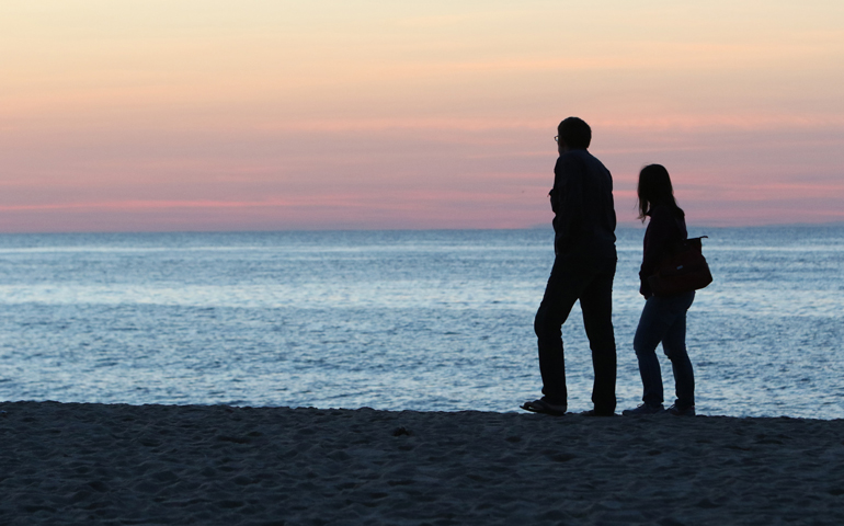 A man and woman walk near the Atlantic Ocean on Race Point Beach in Provincetown, Mass., June 3. (CNS/Gregory A. Shemitz) 