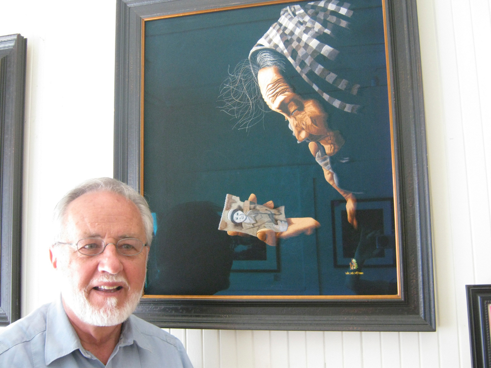 John Kane with his favorite embroidery at Bridging Hope's gallery in Denver (Kathy Coffey)