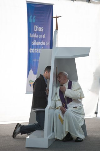 Pope Francis speaks to a young man July 26 as he hears confessions during World Youth Day in Rio de Janeiro. (CNS/L'Osservatore Romano) 