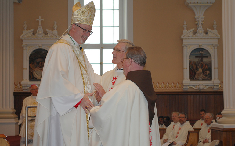 Bishop Christopher Coyne, the new head of the diocese of Burlington, Vt., greets two priests during his installation Mass Thursday at St. Joseph Co-Cathedral in Burlington. (CNS/Vermont Catholic magazine/Cori Fugere Urban)