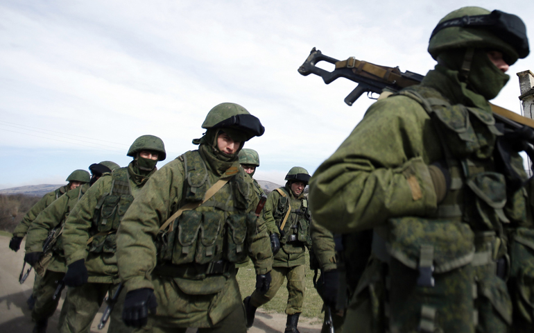 Armed men, believed to be Russian servicemen, march outside a Ukrainian military base in Crimea March 7. (CNS/Reuters/David Mdzinarishvil)