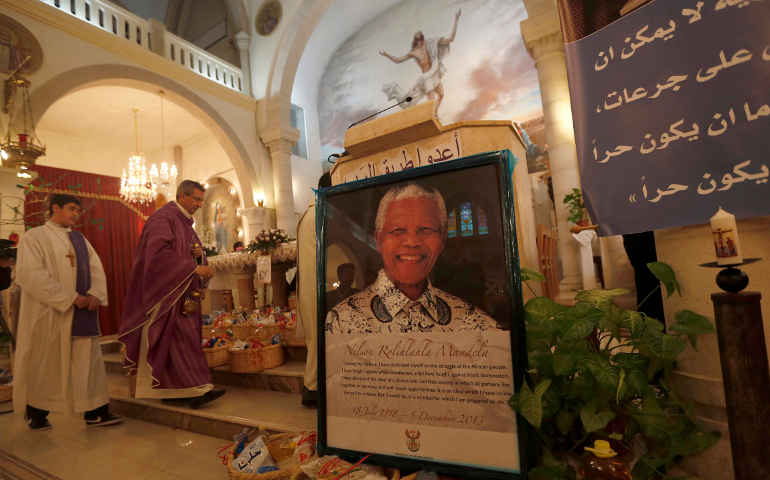 A poster with an image of former South African President Nelson Mandela is displayed during a special prayer service in his honor at the Holy Family Church in the West Bank city of Ramallah Dec. 9. (CNS/Reuters) 