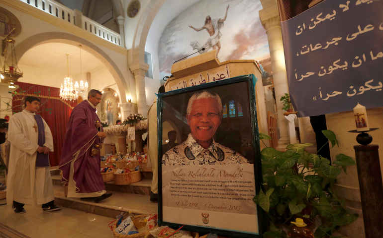 A poster with an image of former South African President Nelson Mandela is displayed during a special prayer service in his honor at the Holy Family Church in the West Bank city of Ramallah Dec. 9. (CNS/Reuters)
