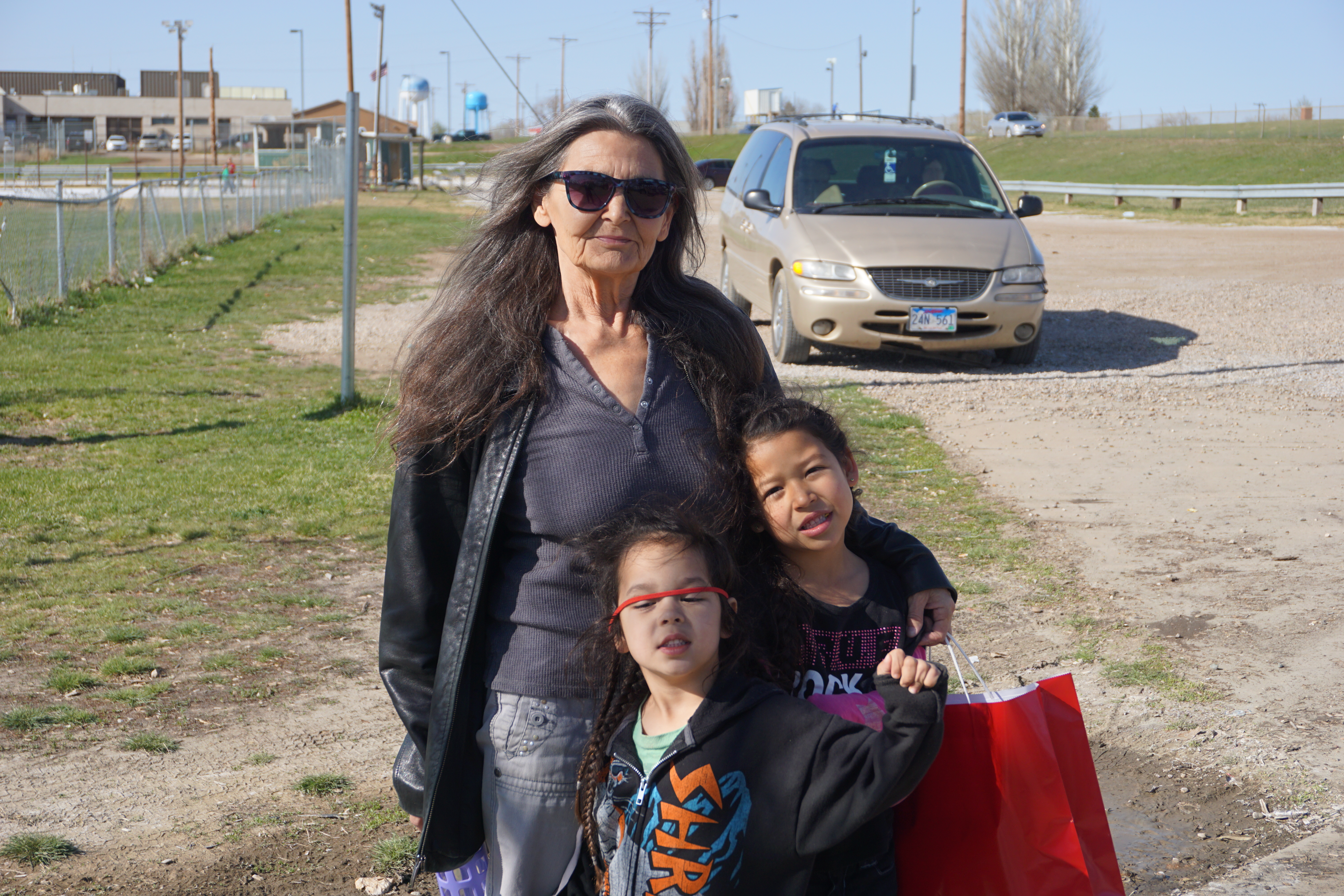 Candace Ducheneaux and two of her grandchildren outside a playground in Eagle Buttle, S.D. (NCR photo/Vinnie Rotondaro)