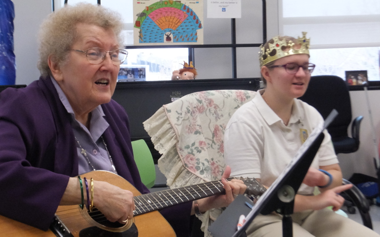School Sister of Notre Dame Maureen Therese Mueller, left, plays music with students at Notre Dame School in Dallas. (Patricia Lefevere)