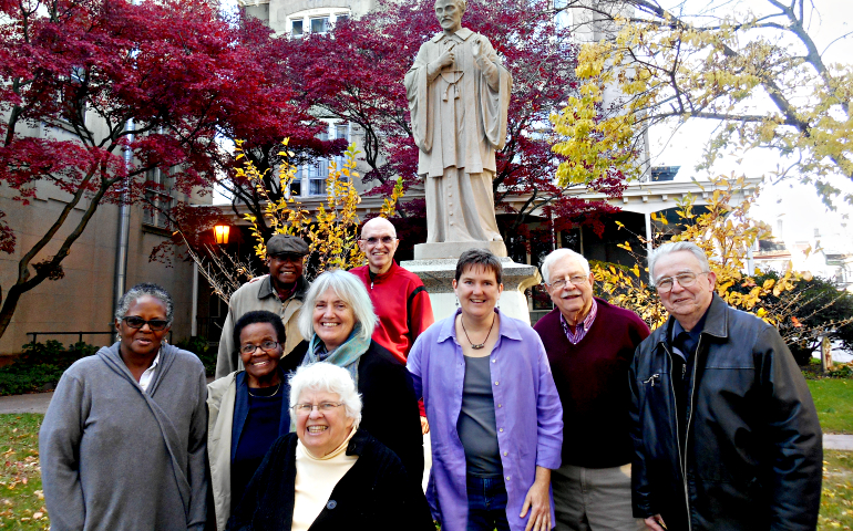 Members of the St. Vincent de Paul Catholic Community in the Germantown section of Philadelphia pose in front of a statue of the parish's patron saint. (Mercedes Gallese)