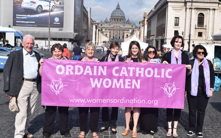 From left to right: Irish Redemptorist Fr. Tony Flannery, Polish activist Alicja Baranowska, British activist Pat Brown, U.S. Anglican Rev. Dana English, Kate McElwee, Erin Saiz Hanna, Miriam Duignan and Jamie Manson hold a sign supporting women's ordination in front of St. Peter's Basilica June 3. (NCR photo)
