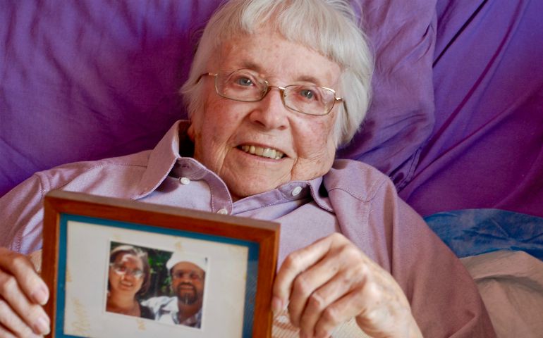 Amityville Dominican Sr. Sally Butler holds a picture of Carlos Cruz and his wife, Georgine Cruz. Butler raised Carlos Cruz from the time his mother died when he was 12 as if he were her own son. (GSR/Dan Stockman)