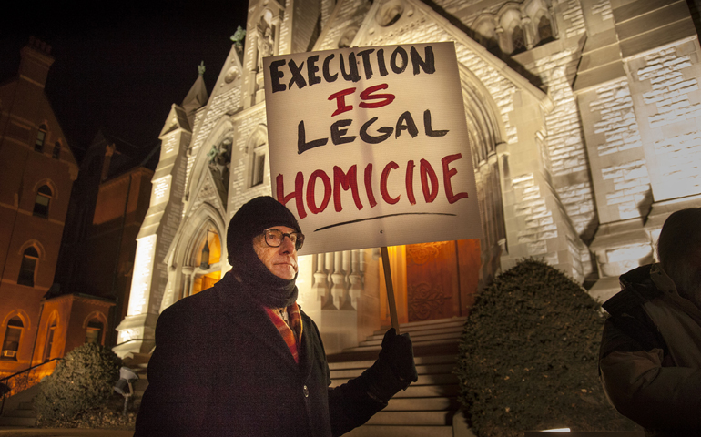 Christian Gohl holds a sign during a Jan. 28, 2014, vigil outside St. Louis University College Church ahead the execution of Missouri death-row inmate Herbert Smulls of St. Louis. Smulls was executed after midnight Jan. 29. (CNS/St. Louis Review/Lisa Johnston)