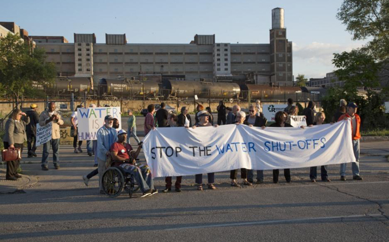Activists line up July 10 outside of the Russell Industrial Center, where the Homrich company is housed, to protest Detroit's water shut-offs for customers who owe too much money on their accounts. (Jim West)