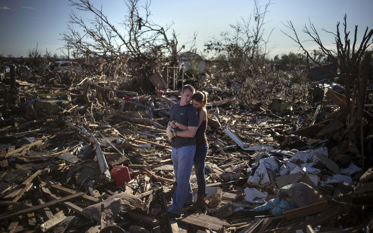 Danielle Stephan and her boyfriend, Thomas Layton, embrace as they salvage items from the ruins of a relative's home in Moore, Okla., May 21, the day after a massive tornado devastated the town. (CNS/Reuters/Adrees Latif)