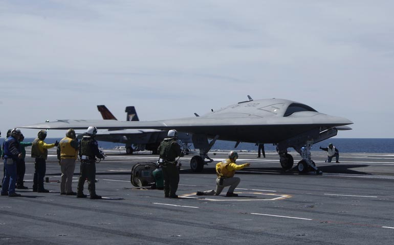 Crew members prepare to launch an X-47B pilot-less drone combat aircraft off an aircraft carrier, the USS George H. W. Bush, in the Atlantic Ocean off the coast of Virginia in 2013. (CNS/Reuters/Jason Reed)