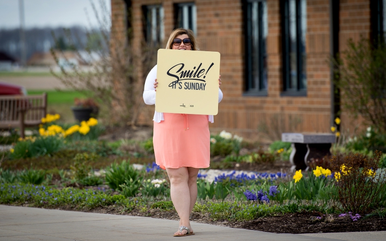 A parishioner welcomes people in the parking lot of St. John XXIII Catholic Community in Perrysburg, Ohio, on Easter Sunday, April 16. (Jeff Montross)