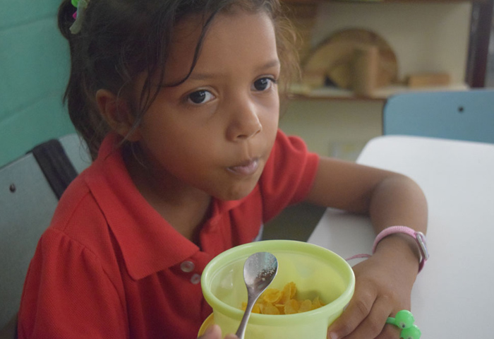 A student eats cereal at the Santo Angel School. As the country's economic crisis has deepened, some families can't afford basic foods like cereal. (Cody Weddle)