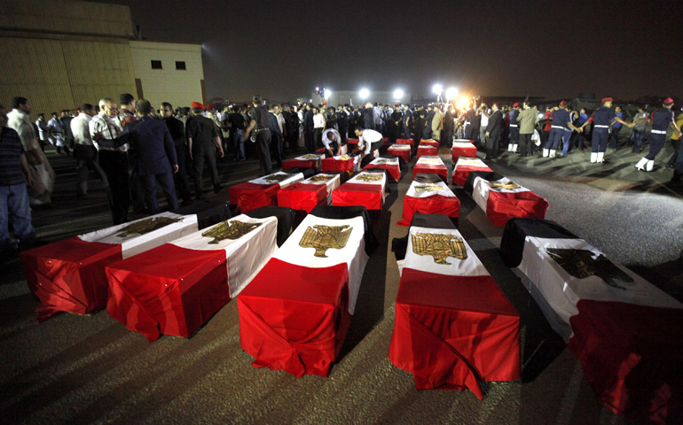 The caskets of 25 policemen killed near the north Sinai town of Rafah lay on the ground after arriving Monday at a military airport in Cairo. The Egyptian policemen were killed and three others wounded in an ambush. (CNS/Reuters/Mohamed Abd El Ghany)