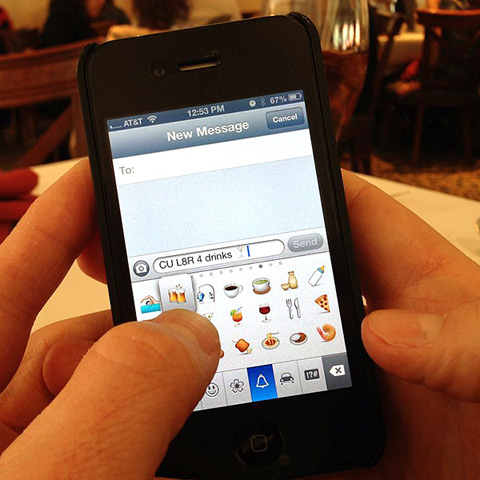 A man adds an emoji character to the end of his text message. (Creative Commons image by Intel Free Press)