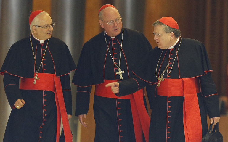 From left: Cardinal Mauro Piacenza, prefect of the Congregation for Clergy; Cardinal Timothy Dolan of New York; and Raymond Burke, prefect of the Supreme Court of the Apostolic Signatura, talk as they walk through Paul VI hall before the morning session of the extraordinary Synod of Bishops on the family Thursday at the Vatican. (CNS/Paul Haring)
