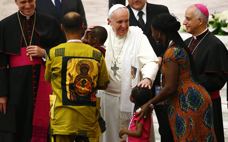 Pope Francis blesses a family Friday during a special audience with participants at a meeting for the new evangelization in Paul VI hall at the Vatican. (CNS/Reuters/Tony Gentile)